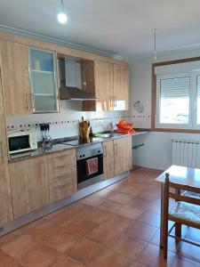 a large kitchen with wooden cabinets and a table at La Casa de Lines in Monforte de Lemos