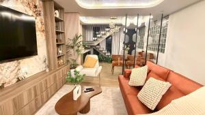a living room with a couch and a television at CB Oasis Signature in Ica