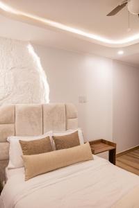 a bedroom with a large white bed with a ceiling at CB Oasis Signature in Ica