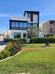 a white house with black windows on a street at CB Oasis Signature in Ica