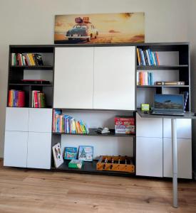 a book shelf with white cabinets and books at Chez D&D Plus in Eschweiler