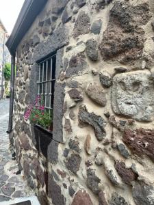 a stone wall with a window and a flower pot at Prendas Paulilatino in Paulilatino
