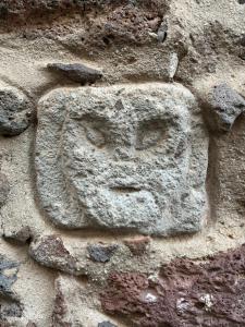 a stone face on the side of a stone wall at Prendas Paulilatino in Paulilatino