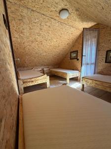 an attic room with two beds and a window at Boravak Tarhaniš Rožaje in Rožaje