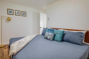 a bedroom with a bed with blue sheets and pillows at Tree-Lined Gold Beach Retreat w/ Multiple Decks! in Gold Beach
