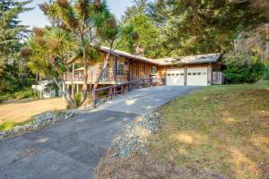 a house with a driveway leading to a garage at Tree-Lined Gold Beach Retreat w/ Multiple Decks! in Gold Beach
