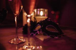 a mask sitting on a table next to two glasses at Maison love rooms in Tours