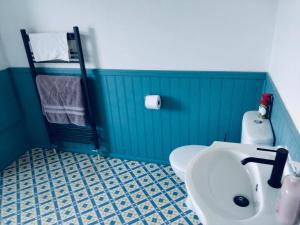 a bathroom with a white sink and a toilet at Sandhurst guest house in Bedford +3 photos