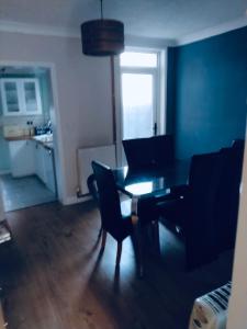 a living room with a dining room table and chairs at Sandhurst guest house in Bedford