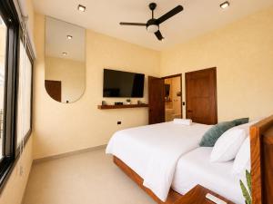 a bedroom with a bed and a flat screen tv at Itza Living Apartments in Flores