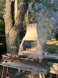 a grill with a bell in front of a tree at La Radura in Roccamorice