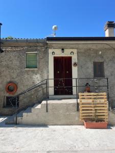 a building with a brown door and stairs in front at La Radura in Roccamorice