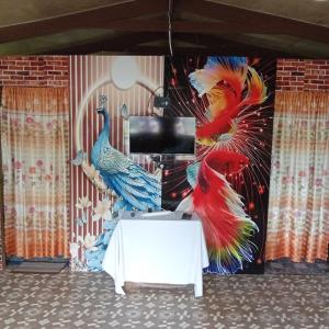 a room with a tv with a peacock mural at PELLY Homestay Explorer in Vunivuthea