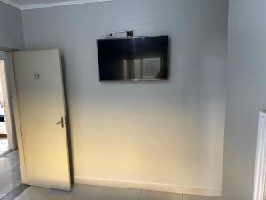 a flat screen tv on a wall next to a door at Hotel Skala - Estacionamento Próprio no Local - 1 km Parque Antônio Pezzolo e 700 métros da Estação de Trem Prefeito Saladino in São Paulo
