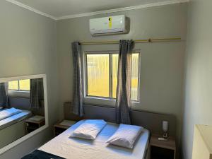 a small bedroom with a bed and a window at Hotel Skala - Estacionamento Próprio no Local - 1 km Parque Antônio Pezzolo e 700 métros da Estação de Trem Prefeito Saladino in São Paulo