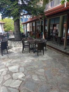 a patio with chairs and a table and a tree at FANTINO HOTEL in Domnista