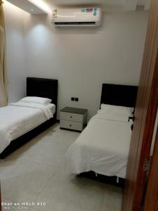 a bedroom with two beds and a air conditioner at BELLA ViTA in Jeddah