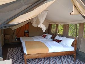 a bedroom with two beds in a tent at Kambu Mara Camp in Sekenani
