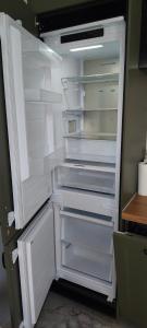an empty refrigerator with its door open in a kitchen at Apartament Sobieskiego in Puck +7 photos