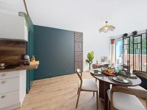 a kitchen and dining room with a table and chairs at L'Amour des Îles - Centre - Plage - Parking in Cabourg +28 photos