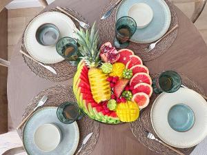a table with a plate of fruit on it at L'Amour des Îles - Centre - Plage - Parking in Cabourg