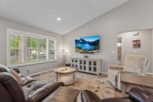 a living room with a couch and chairs and a tv at Riverside Harbor House in Post Falls ID in Post Falls