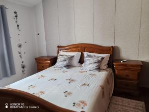 a bedroom with a bed with a wooden headboard and pillows at Villa Luisa Torres in Argozelo