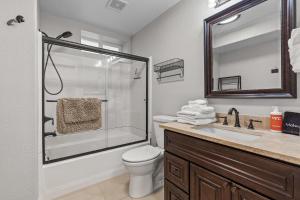 a bathroom with a shower and a toilet and a sink at Riverside Harbor House in Post Falls ID in Post Falls +33 photos