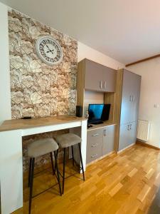 a kitchen with a stone wall with a clock on it at Apartman 14 in Doboj
