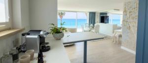 a kitchen with a table and a dining room with the ocean at Ivory Dimora di Charme in Terracina