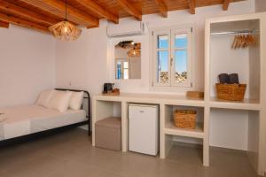 a room with a desk with a bed and a window at Omnia Apartments Amorgos No2 in Amorgos