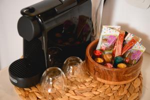 a table with a bowl of candy and a microwave at Omnia Apartments Amorgos No2 in Amorgos +7 photos