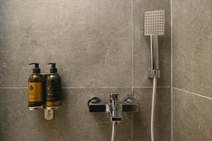 a shower with two bottles of wine on a wall at Omnia Apartments Amorgos No2 in Amorgos