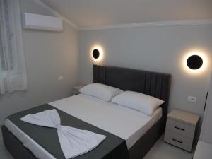 a bedroom with a bed with two white pillows at Pateriku Apartments in Shkodër