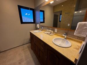 a bathroom with two sinks and a large mirror at Villamagna, cabaña con jacuzzi en Potrerillos in Potrerillos +37 photos