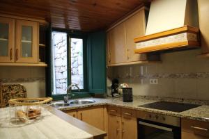 a kitchen with wooden cabinets and a sink and a window at La Divina 1 in Ribadavia