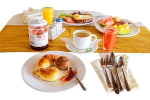 a table with a plate of breakfast foods and a cup of coffee at EDEN PALACE KIGALI AIRPORT AND APARTMENTs in Kigali