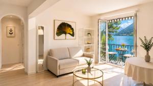 a living room with a couch and a large window at Rivalago - Lake front apartment on Lake Promenade in Brissago