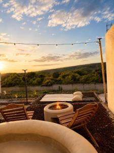 a backyard with a fire pit and chairs and a sunset at El campanario Glamping in Jalcomulco