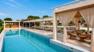 a swimming pool with chairs and a pavilion at El campanario Glamping in Jalcomulco