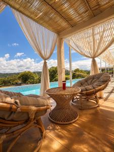 a patio with chairs and a table and a pool at El campanario Glamping in Jalcomulco