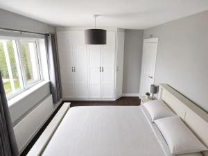 a white room with a bed and a window at Hill House Westport in Mayo