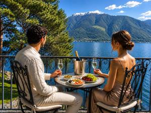 a man and woman sitting at a table with a plate of food at Rivalago - Lake front apartment on Lake Promenade in Brissago