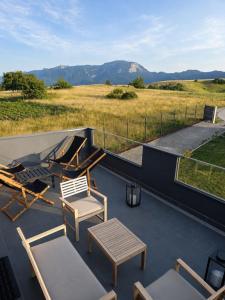 a patio with a table and chairs on a roof at Peak Vista A-Frame in Sarajevo