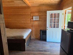 a bedroom with a bed in a wooden cabin at Noah's Ark Campground in Malakwa
