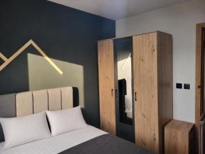 a bedroom with a bed and a wooden cabinet at Peak Vista A-Frame in Sarajevo