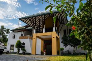 a white house with a gambrel roof at Aurelia Grand Hotel in Kitulgala