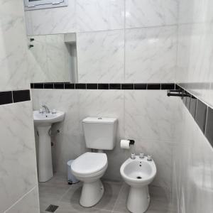 a white bathroom with a toilet and a sink at Departamento LUNA DE BELEN in Belén +8 photos