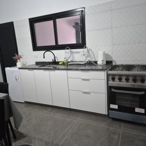 a kitchen with a sink and a stove at Departamento LUNA DE BELEN in Belén