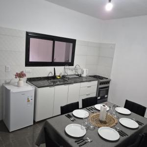 a kitchen with a table with chairs and a sink at Departamento LUNA DE BELEN in Belén